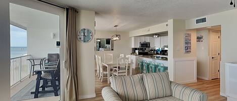 A spacious living area with a balcony, a dining area, and a kitchen.