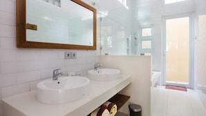A modern bathroom with two sinks, a large mirror, and a shower area. - Donguri House Bali (Kedonganan)