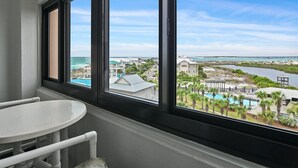Una stanza con un'ampia finestra che si affaccia su una zona ricettiva, con piscina e edifici.