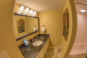 A bathroom with a sink, mirror, and two towels. - Gorgeous, enclosed balcony unit! One free beach set up daily. (Destin)