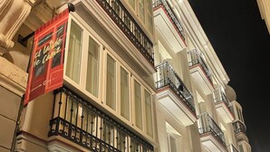 A multi-story building with balconies, a sign for 'El Vino de Caniza', and a 'Soho Boutique Pallero' sign. - Apartamentos Soho Boutique Palillero (Cádiz)