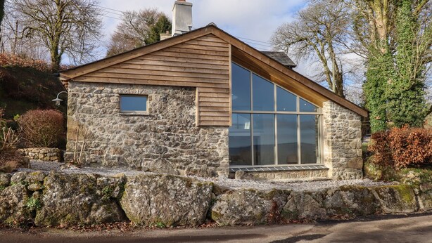 A stone house with a large window and a chimney. - Beckaford View (Newton Abbot)