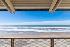 A beach view from under a wooden structure with a metal fence in the foreground. - Sand Dollar Beachfront Home, Direct Beach Access! (La Selva Beach)