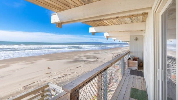 A beach house with a wooden deck overlooking the ocean. - Sand Dollar Beachfront Home, Direct Beach Access! (La Selva Beach)