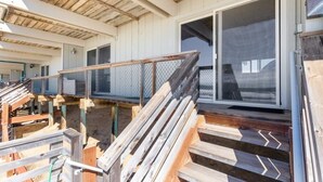 A construction site with wooden steps leading to a covered area, metal fencing, and a large sliding glass door. - Sand Dollar Beachfront Home, Direct Beach Access! (La Selva Beach)