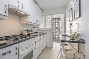 Une cuisine avec des meubles blancs, une cuisinière et un évier.