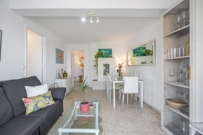 Un salon moderne comprenant un canapé, une table basse, un coin repas et une cuisine.