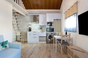 A compact kitchen with a washing machine, microwave, and oven.
