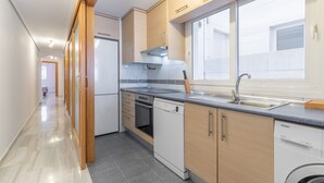 A modern kitchen with a dishwasher, oven, and a window with a view. - Apartment "Avenida Masnou" close to the Sea with Shared Pool & Wi-Fi (Calpe)