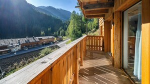 A wooden balcony with a view of a train station and mountains. - Apartment "Grogg 608 I" with Mountain View, Garden & Wi-Fi (Martello)