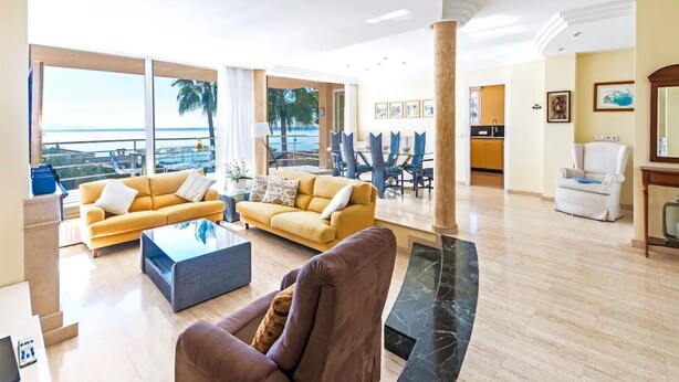 A spacious living area with two sofas, a coffee table, and a view of the ocean.