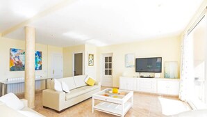 A modern living room with a sofa, coffee table, and TV.