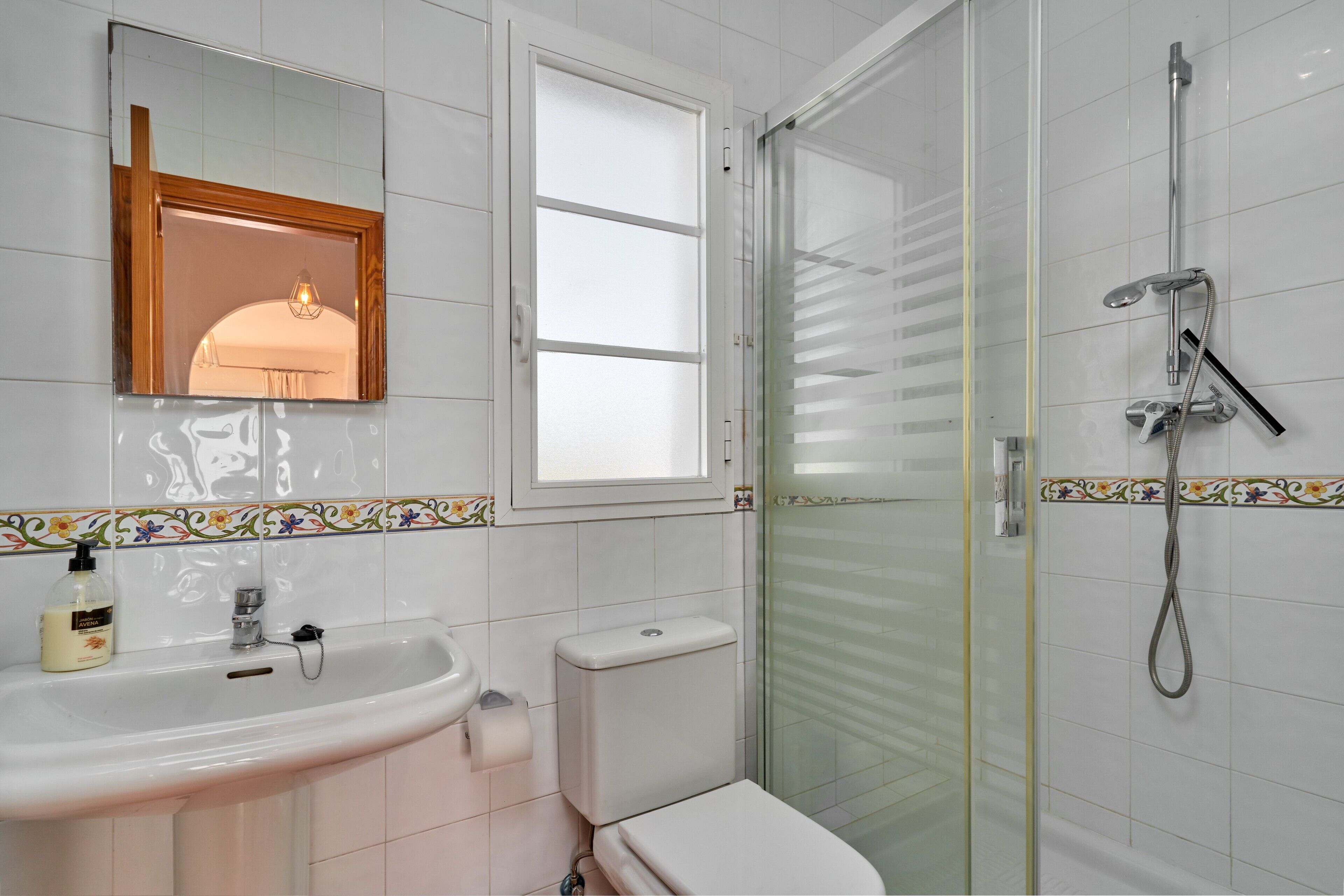 Un baño con lavamanos, inodoro y ducha.