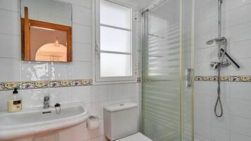 Un baño con lavamanos, inodoro y ducha.