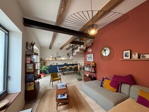 Una sala de estar moderna con sofá, mesa de centro y comedor con sillas y una mesa.