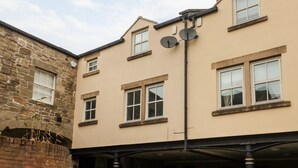 Un bâtiment doté d’une façade en pierre et d’une partie supérieure de couleur beige.
