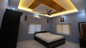 A bedroom with a bed, ceiling fan, recessed lighting, and two windows with blinds.