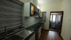 A modern kitchen with a marble backsplash, stainless steel sink, and a built-in oven.