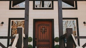 Ein zweistöckiges Gebäude mit Holzfassade und einer dunkelbraunen Tür.