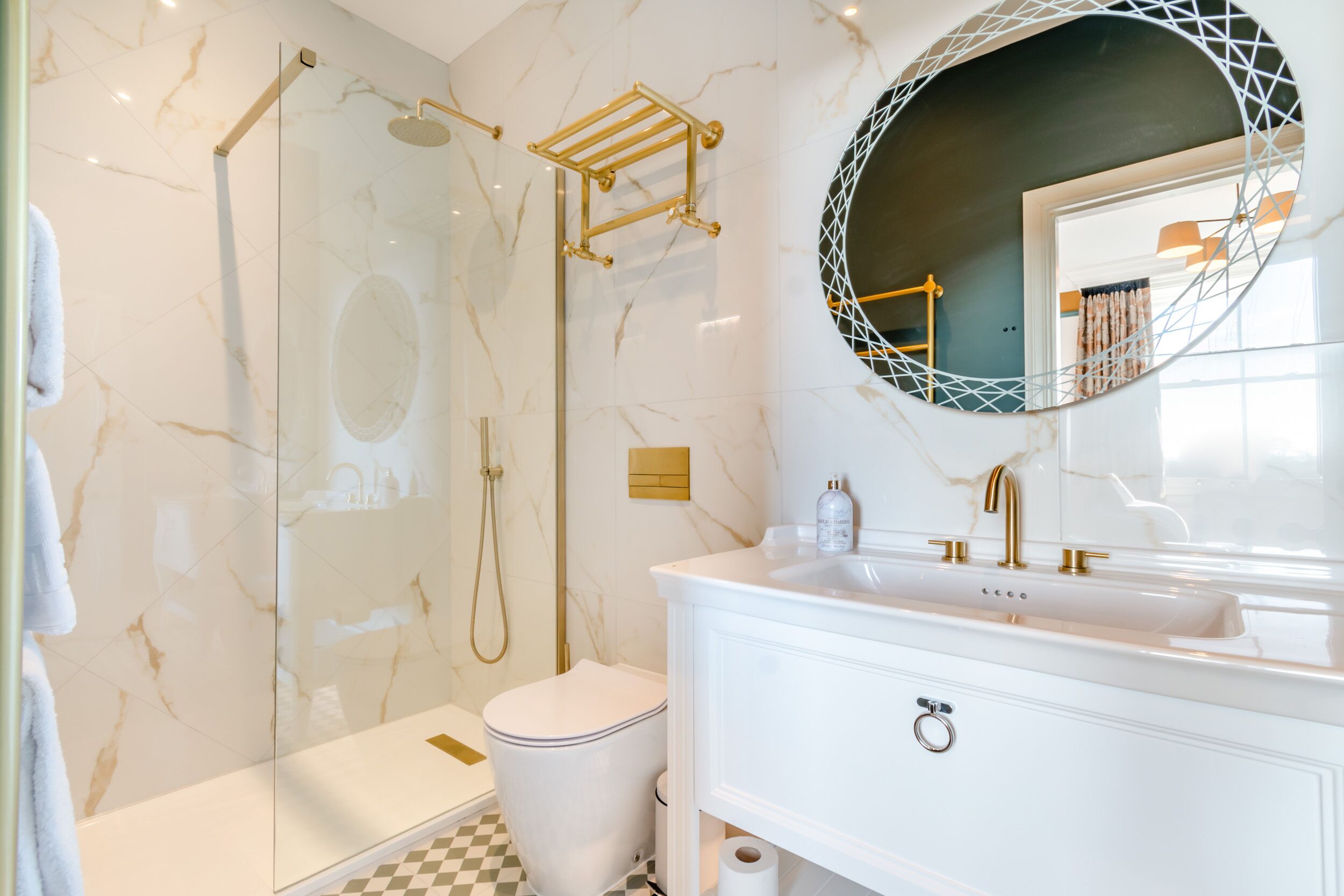 A modern bathroom with a glass-enclosed shower, a white toilet, and a vanity with a large mirror.