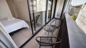 A balcony with a bed, two chairs, and a view of the city. - Luminous apt 4ppl Palermo Soho (Buenos Aires)