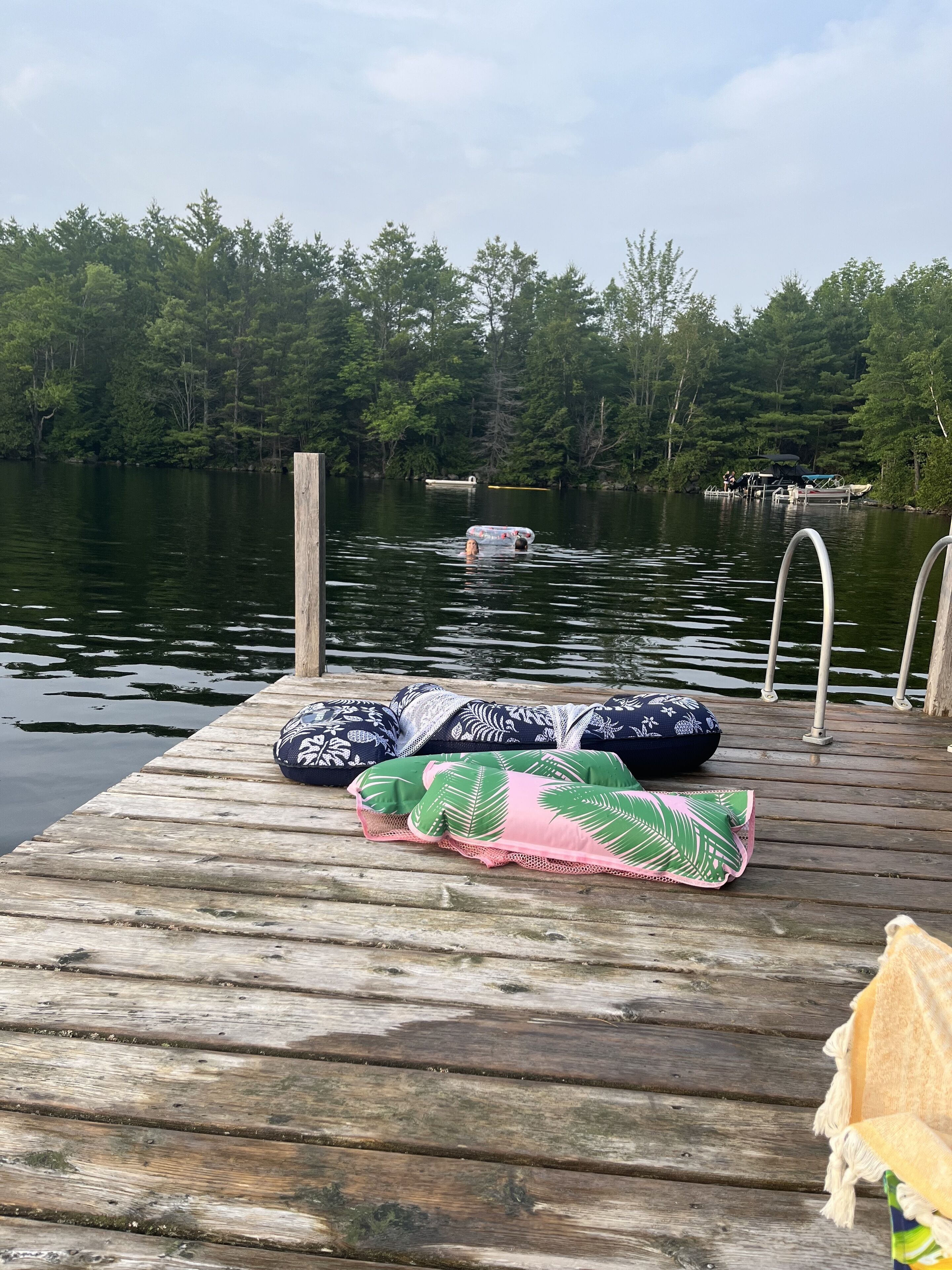 A wooden dock with a row of pillows and a blanket.