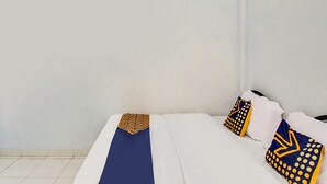 Een hotelkamer met een bed, kussens en een dekbed.