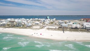Eine Küstenlandschaft mit Strandhäusern, darunter mehrstöckige Gebäude und ein Sandstrand.
