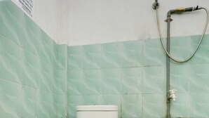 Une salle de bain avec des toilettes, une douche et des carreaux décorés.