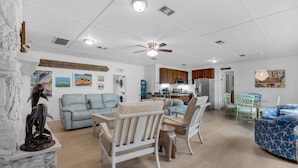 A spacious living room with a dining area, a kitchen, and a laundry room.