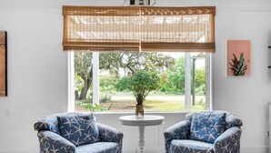 A room with two blue armchairs facing a window with a view of greenery outside. - 🏝️In the Heart of Navarre-Bungalow By the Sea-Mermaid (Navarre)