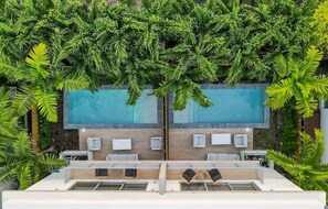 An aerial view of a rooftop pool area with a rectangular pool, surrounded by lush greenery and modern outdoor seating. - Modernista 2,  Townhome with Pool by Coconut Grove (Miami)