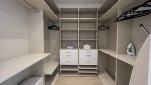 A walk-in closet with multiple shelves, drawers, and hanging space. - Modernista 2,  Townhome with Pool by Coconut Grove (Miami)