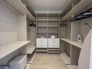 A walk-in closet with multiple shelves, drawers, and hanging space. - Modernista 2,  Townhome with Pool by Coconut Grove (Miami)
