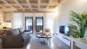 A modern living room with a sofa, two armchairs, a coffee table, a TV, and a potted plant. - BARCELONA TOUCH APARTMENTS - ROSICH (L'Hospitalet de Llobregat)