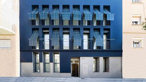 A modern building with a dark facade, multiple windows, and a visible entrance. - BARCELONA TOUCH APARTMENTS - ROSICH (L'Hospitalet de Llobregat)