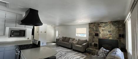 A modern kitchen with a built-in microwave, a bar area, and a stone accent wall.