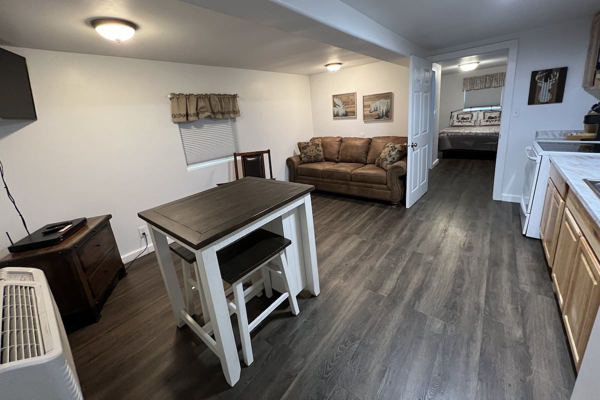 A compact living space with a dining table, a sofa, and a kitchenette.
