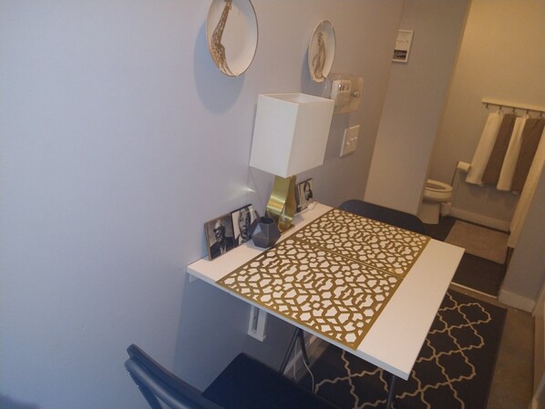 A bathroom with a white sink, a mirror, a towel rack, and a patterned floor mat.