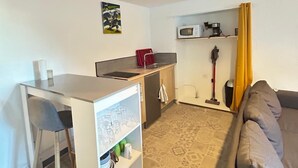 A compact living space with a kitchenette, a dining area, and a seating area.