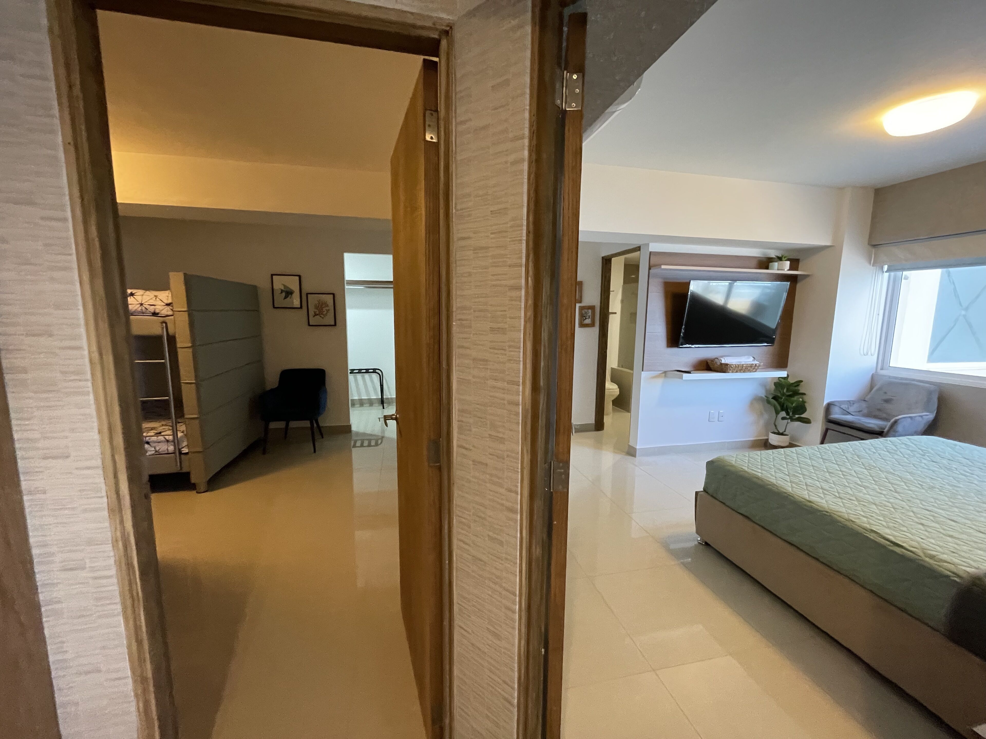 Une chambre moderne avec un lit, une télévision et un espace bureau.