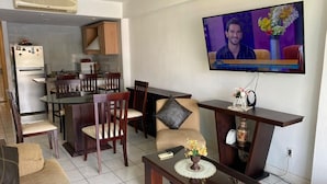 A living room with a TV, a dining area, and a kitchen. - Puesta del Sol (Mazatlán)