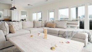 Un salon moderne avec un canapé d’angle, une table basse et un jeu de puzzle.