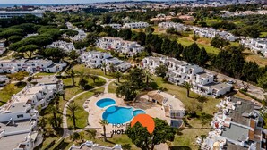 Zona residencial con edificios blancos, una piscina y un club social.