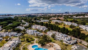 Zona residencial con edificios blancos, una piscina y un club social.