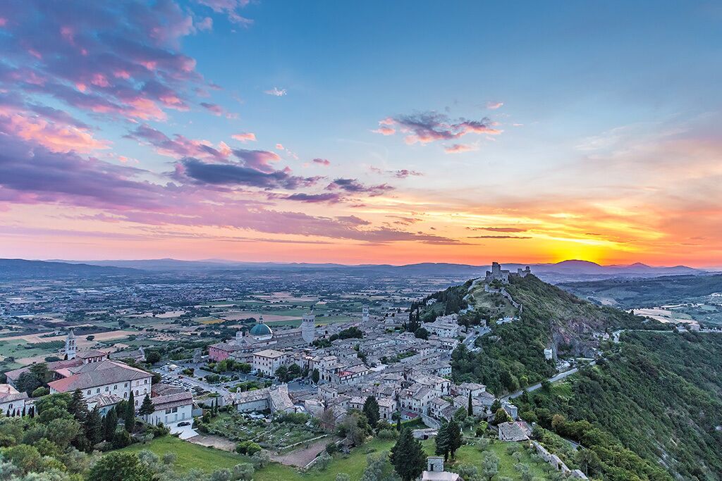 Una cittadina con edifici storici, una chiesa importante e un castello su una collina.