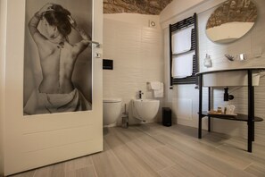 A modern bathroom with a toilet, bidet, and sink. There is a mirror above the sink and a towel rack. - C' ERA UNA VOLTA  (Assisi)