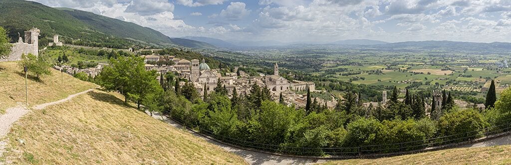 A historic town with ancient architecture, a prominent church, and a scenic view of the countryside.