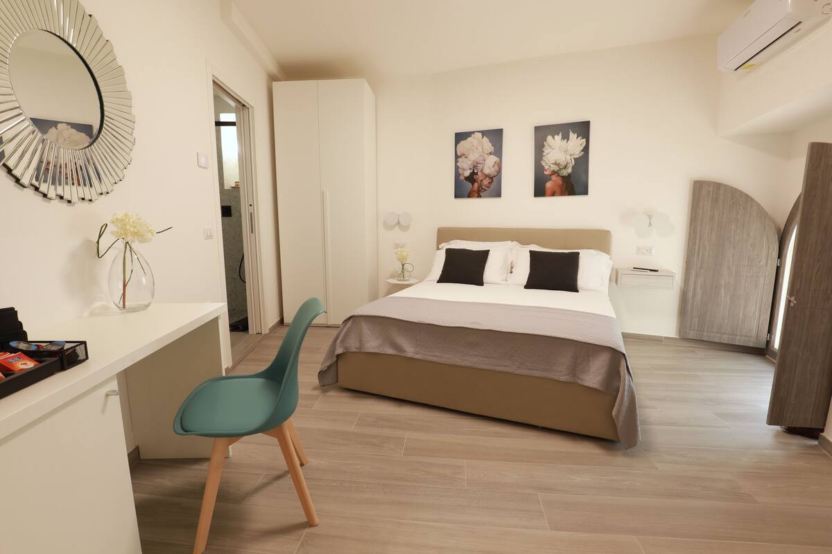 A modern bedroom with a bed, a desk, and a chair.