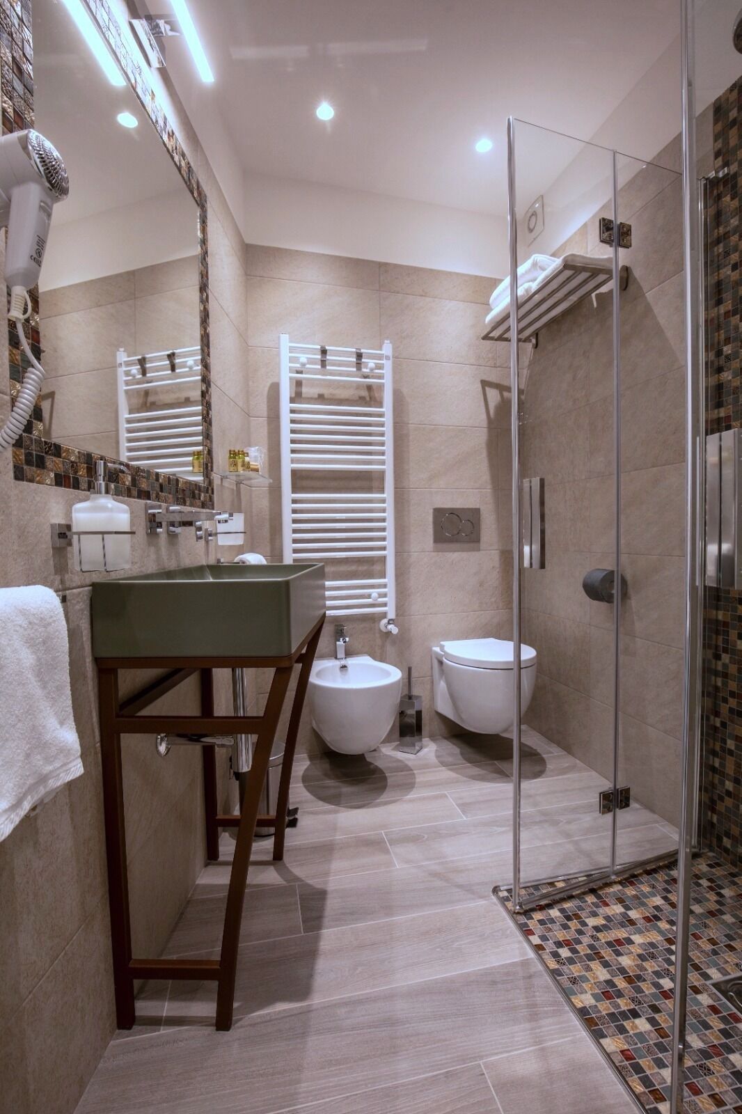A modern bathroom with a bidet, a glass-enclosed shower, and a vanity with a sink and mirror.